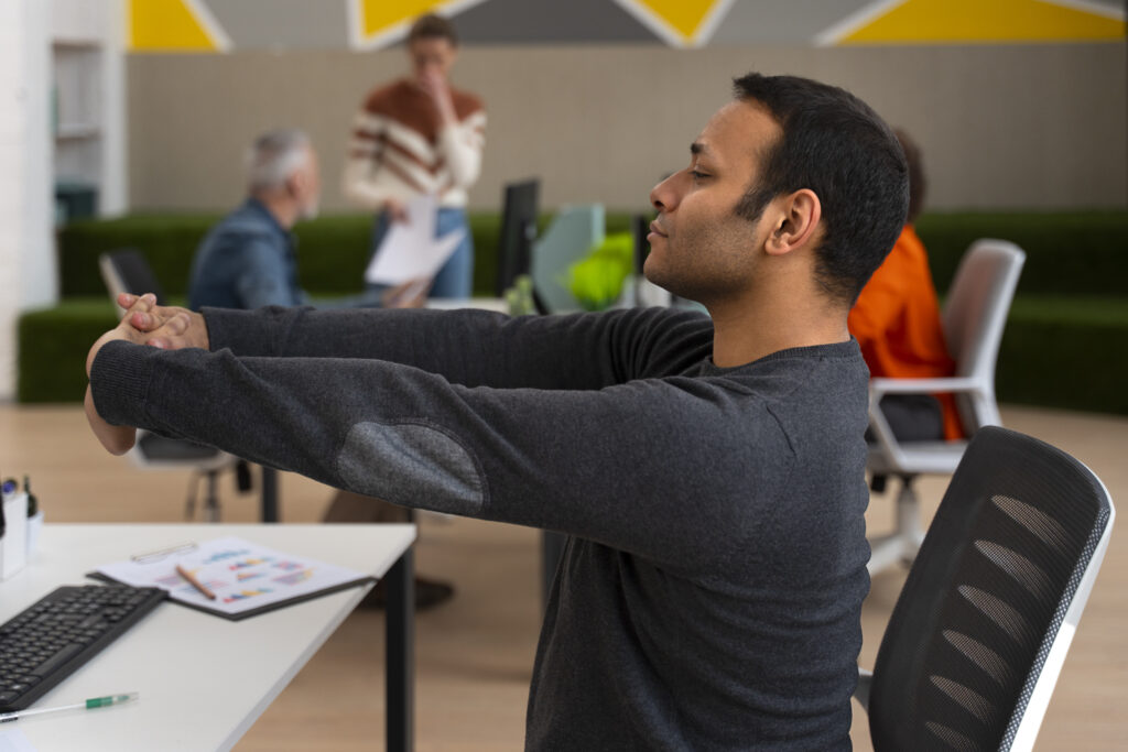 man in office stretching on a work day